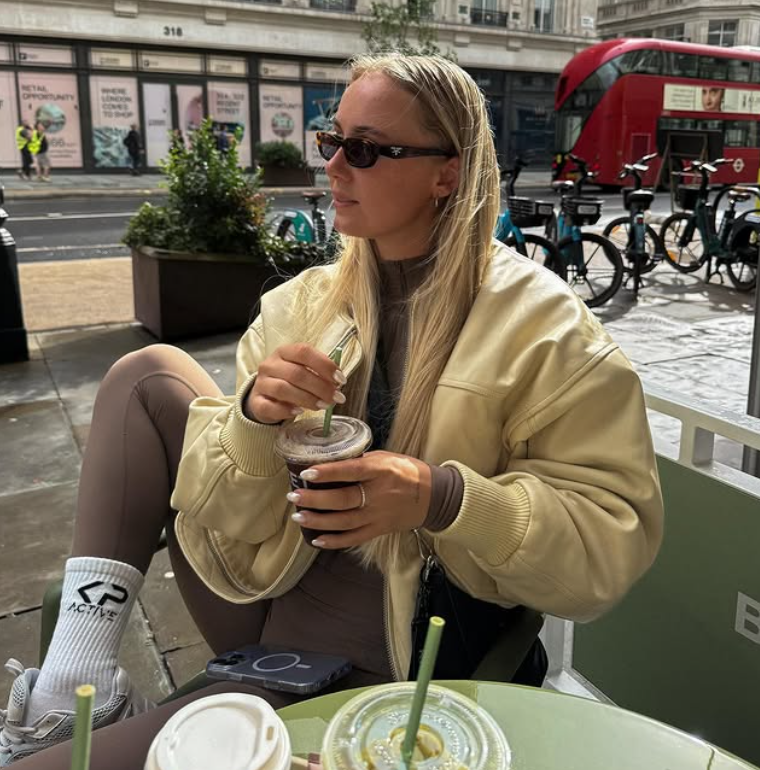 Myron koops geniet van een gezonde drank op een terras – moment van ontspanning en energie, passend bij de VYMAX-community voor gezondheid en vitaliteit.